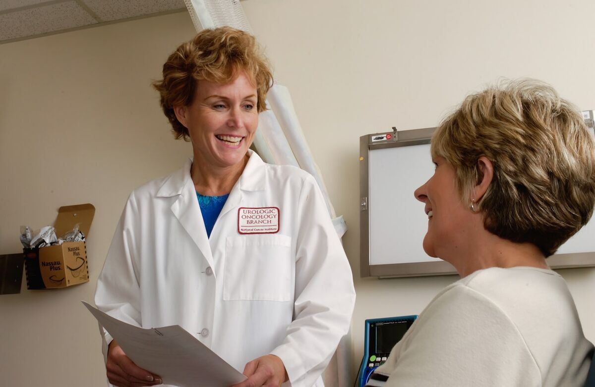 A doctor in conversation with a colleague at a clinic.